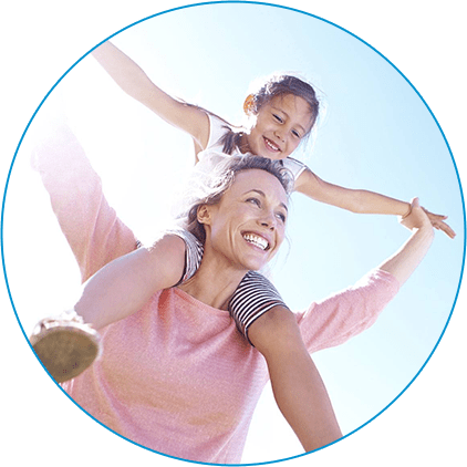 A happy mother with her young daughter on her shoulders.